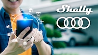 Eine Person nutzt ein Smartphone, daneben Logos von Shelly und Audi.