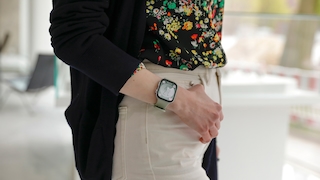 Huawei Watch Fit 3 am Handgelenk einer Frau. Sie trägt eine weiße Jeans und eine geblümte Bluse.
