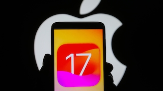 iPhone mit dem Logo von iOS 17. Im Hintergrund ist das Apple-Logo zu sehen