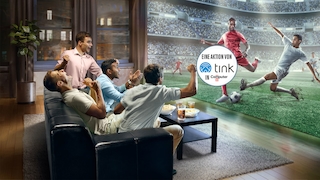 Ein paar Männer sehen sich im Wohnzimmer begeistert ein Fußballspiel an.