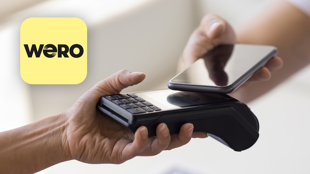 Person hält Handy vor Kartenlesegerät