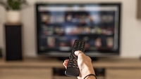 Person hält Fernbedienung in der Hand