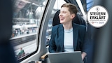 Eine Frau sitzt im Zug am Laptop.