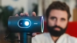 Redakteur Richard W. Schaber zeigt im Test den Beamer JmGO PicoPlay+ in die Kamera.
