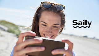 Lachende Frau mit Handy am Strand und Anbieter-Logo von Saily