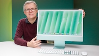 Testredakteur Sven Schulz mit dem Apple iMac vor einem farbigen Hintergrund.