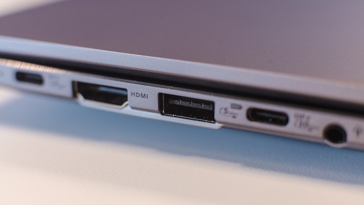 Nahaufnahme der linken Seite des silbernen Asus Expertbook PM3606CKA mit sichtbaren Anschlüssen, darunter HDMI, ein USB-Port und eine runde Klinkenbuchse.
