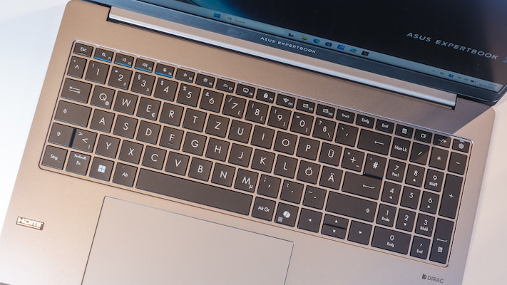 Schräg von oben fotografierte Tastatur des Asus ExpertBook PM3606CKA mit schwarzem Tastenfeld, deutschem Layout inklusive Nummernblock, darunter ein großes Touchpad in einem grauen Gehäuse.