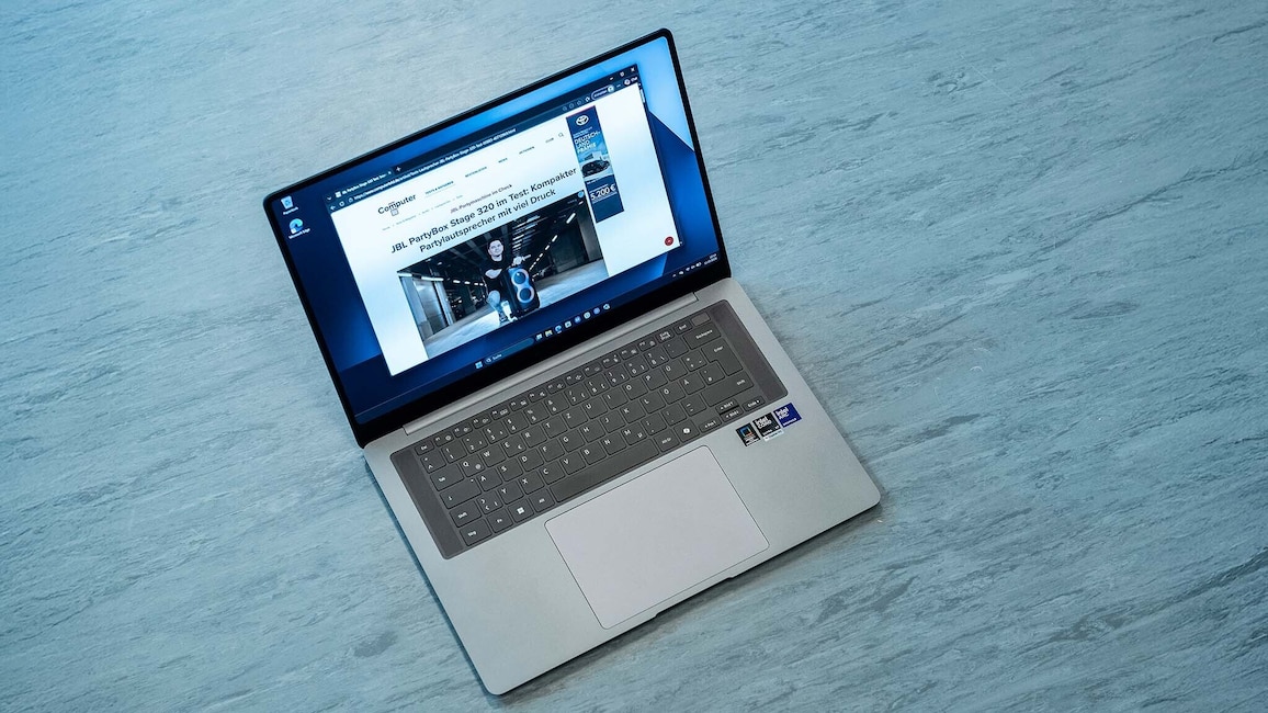 Ein aufgeklapptes Samsung Galaxy Book6 Pro liegt auf einem Tisch. Zu sehen sind Tastatur, großes Touchpad und das eingeschaltete Display mit einer geöffneten Webseite.
