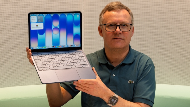 Testredakteur Sven Schulz hält das MacBook Neo mit aufgeklappten Display in die Kamera-