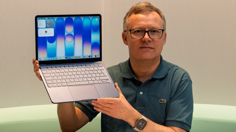 Testredakteur Sven Schulz hält das MacBook Neo mit aufgeklappten Display in die Kamera-