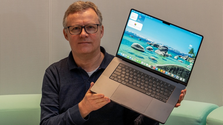 Testredakteur Sven Schulz hält das Apple MacBook Pro 16 Zoll aufgeklappt in die Kamera.