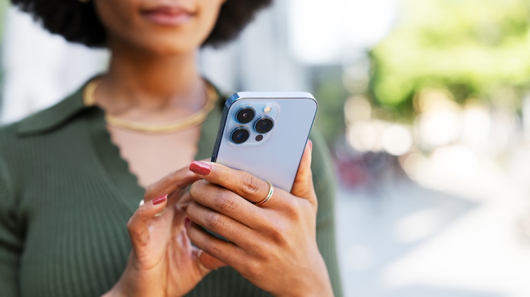 Nahaufnahme einer frau, die auf ihr iPhone Pro schaut
