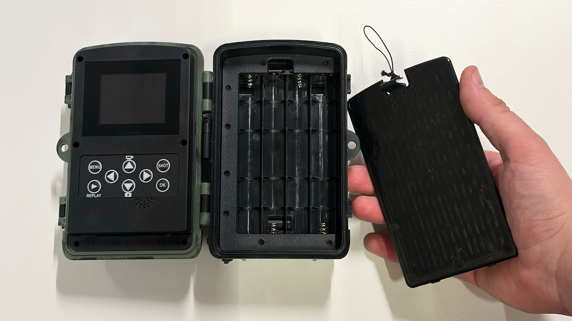 eöffnete Wildkamera mit leerem Batteriefach und abgenommenem Batteriefachdeckel.