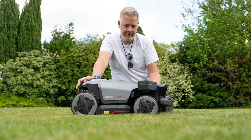 Roborock RockMow Z1 LiDAR und Testredakteur auf einer Rasenfläche im Garten.