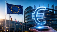 Eine Hand hält ein Smartphone, über dem ein leuchtendes Euro-Symbol schwebt; im Hintergrund sind eine EU-Flagge, mehrere Nationalflaggen und ein modernes Parlamentsgebäude zu sehen.