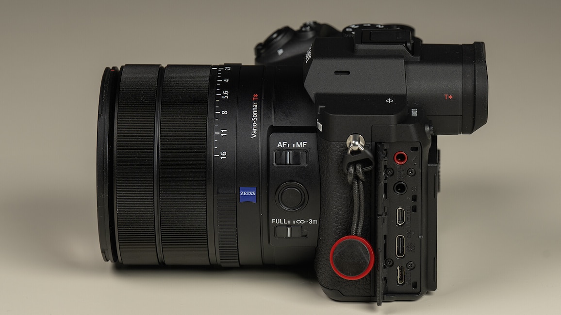 Ansicht der Sony Cyber-shot RX10 V von links mit geöffneter Klappe für die Anschlussbuchsen.
