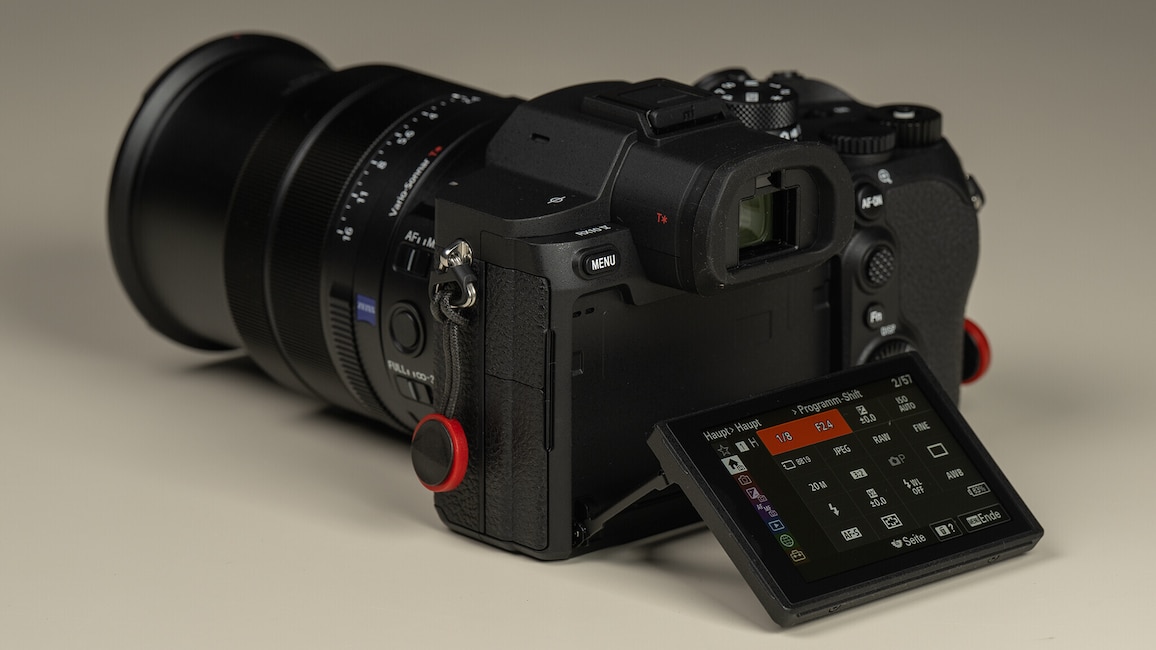 Die Sony Cyber-shot RX10 V von schräg hinten mit ausgeklapptem Display. Auf dem Display ist das Kameramenü zu sehen.