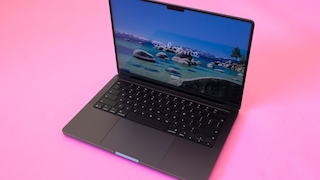 Geöffnetes MacBook Pro auf pinkem Grund