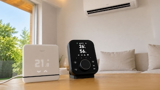 Smarte Klimasteurungen von tado, SwitchBot und eine Kliaanlage an der Wand in einem Wohnzimmer