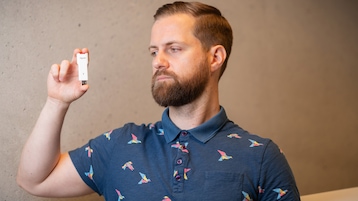 Männliche Person mit FritzWLAN Stick 6700 in der Hand