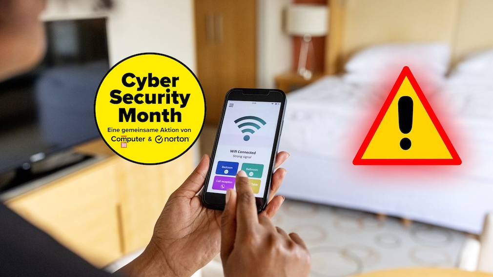 Eine Person hält ein Smartphone in beiden Händen in einem Hotelzimmer. Auf dem Smartphone-Bildschirm ist eine WLAN-Anzeige mit dem Text „Wifi Connected“ und mehreren farbigen Schaltflächen zu sehen. Im Hintergrund befinden sich ein Bett, ein Nachttisch mit Lampe, ein Schrank und ein Fernseher. Rechts im Bild ist ein großes gelbes Warnsymbol mit schwarzem Ausrufezeichen und rotem Rand eingeblendet. Der Hintergrund ist teilweise unscharf dargestellt.