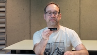 Redakteur sitzt an einem Tisch und schaut auf die SanDisk Optimus GX Pro 8100
