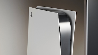 Weiße Sony PlayStation 5 im Hochformat vor neutralem Hintergrund. Die Konsole ist aus schräger Perspektive aufgenommen, das schwarze Mittelteil wird von den markanten weißen Seitenabdeckungen eingerahmt. Das PlayStation-Logo ist auf der Vorderseite sichtbar. Die PS5 steht stellvertretend für Sonys aktuelle Konsolengeneration, während die PlayStation 6 weiter auf sich warten lässt.