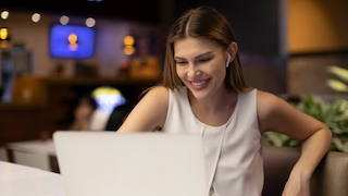 Frau an Laptop mit Kopfhörern
