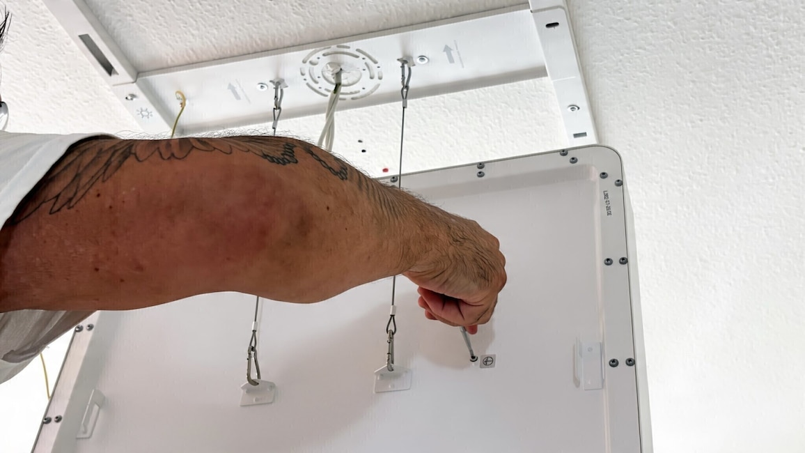 Praktisch bei der Montage: Das schwere Panel hängt während des Anschlusses an Sicherungsseilen unter der Halterung und muss nicht dauerhaft über Kopf gehalten werden.