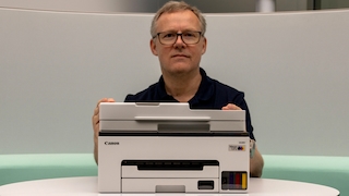 Testredakteur Sven Schulz sitzt hinter dem Canon Maxify GX2051.