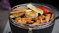 Das Grillgut wird eher sanft gegart als kräftig geröstet. Direkt über der Kohle entsteht die stärkste Bräunung.