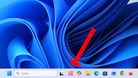 Screenshot eines Windows-11-Desktops mit dem blauen Standardhintergrund. Ein großer roter Pfeil zeigt auf ein Symbol in der Taskleiste. Das Symbol besteht aus zwei überlappenden Rechtecken in Hell- und Dunkelgrau. Rechts daneben sind weitere Programmsymbole zu sehen, darunter Opera, Microsoft 365, Datei-Explorer, Microsoft Edge, Microsoft Store, Outlook, Google Chrome und Firefox. Links befinden sich die Start-Schaltfläche und das Suchfeld.
