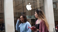 Zwei Frauen vor einem Apple-Store entlang. Da Apple-Logo leuchtet.
