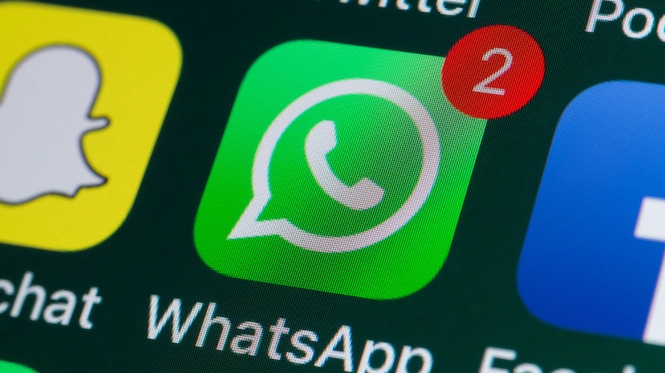 Nahaufnahme eines Smartphone-Bildschirms mit dem WhatsApp-Symbol auf grünem Hintergrund. In der oberen rechten Ecke des Symbols befindet sich ein roter Benachrichtigungskreis mit der Zahl 2. Links ist ein Teil des Snapchat-Symbols, rechts ein Ausschnitt eines weiteren App-Symbols zu sehen. Unter dem WhatsApp-Symbol steht die Beschriftung „WhatsApp“.
