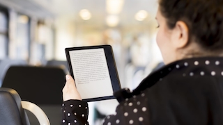 Frau hält eBook-Reader in der Hand
